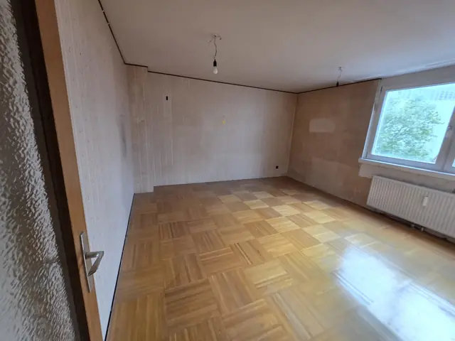 Messie Entrümpelung 1190 Wien nachher: leeres Zimmer mit Parkettboden und Fenster