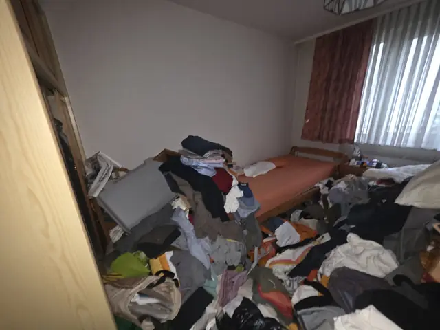 Messie Entrümpelung 1190 Wien vorher: Zimmer mit Bett und Kleiderbergen am Boden