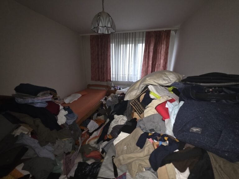 Messie Räumung Krems an der Donau vorher – stark vollgestelltes Zimmer mit Kleidung und Gegenständen