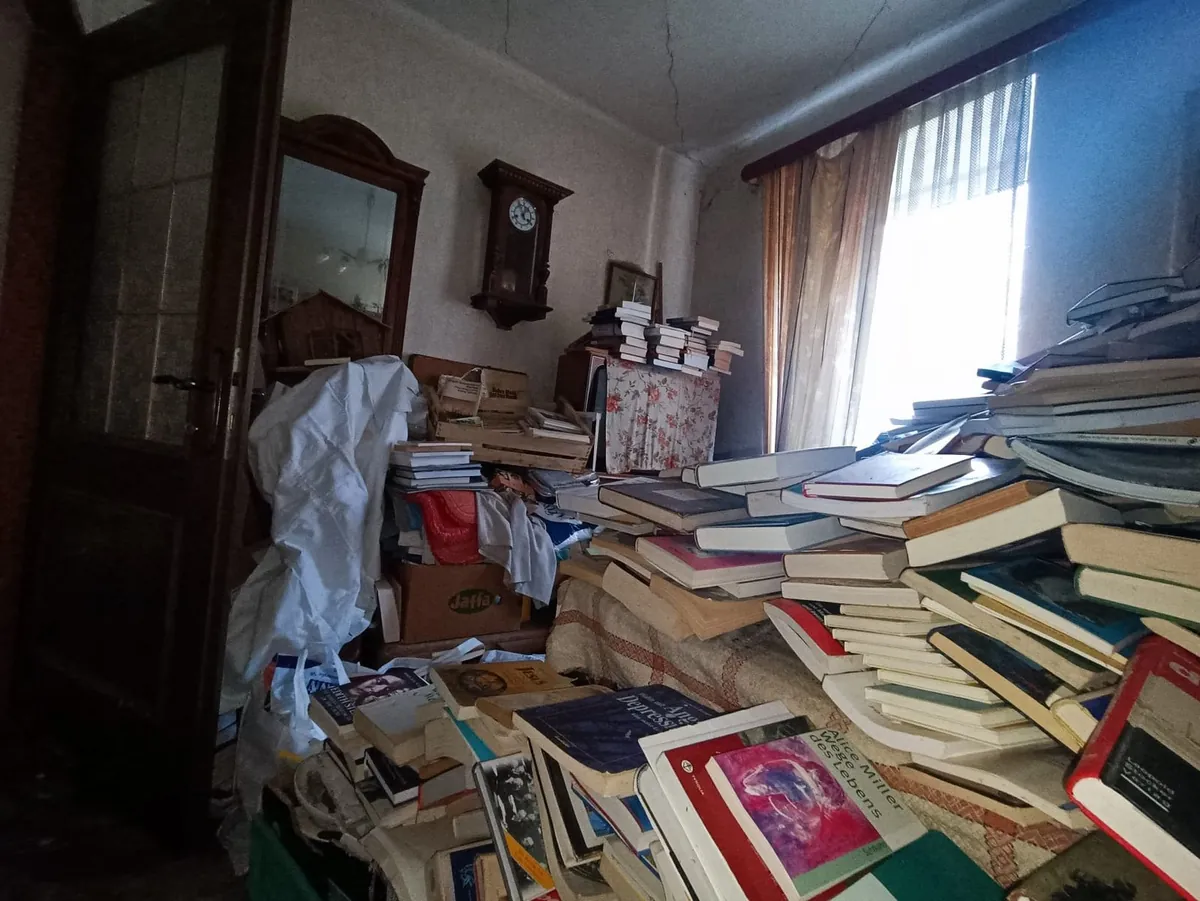 Messie Wohnung räumen Niederösterreich: Zimmer in Puchberg am Schneeberg vor der Räumung mit Bücherbergen, Schrank und Wanduhr